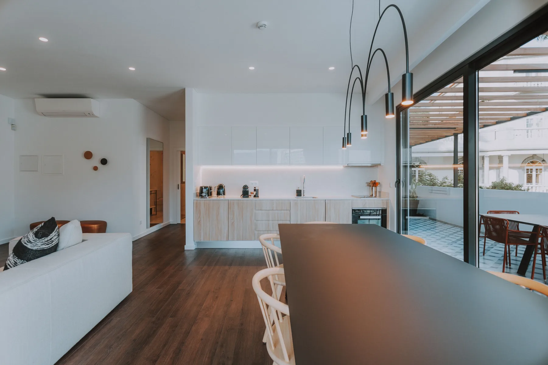 Una sala-comedor de planta abierta con cocina y una pared de vidrio corrediza.