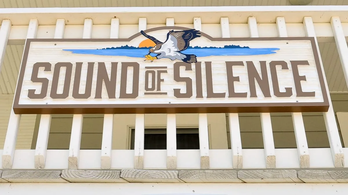 Un letrero grande que dice «Sound of Silence» está montado sobre una barandilla exterior blanca.
