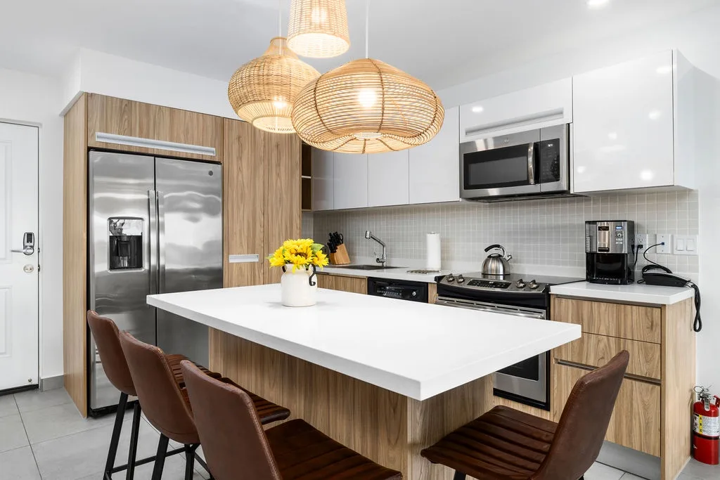 Gather around this sleek kitchen island for your morning coffee or prep meals together. Modern appliances, ample counter space, and warm wood tones create a welcoming heart of your home.
