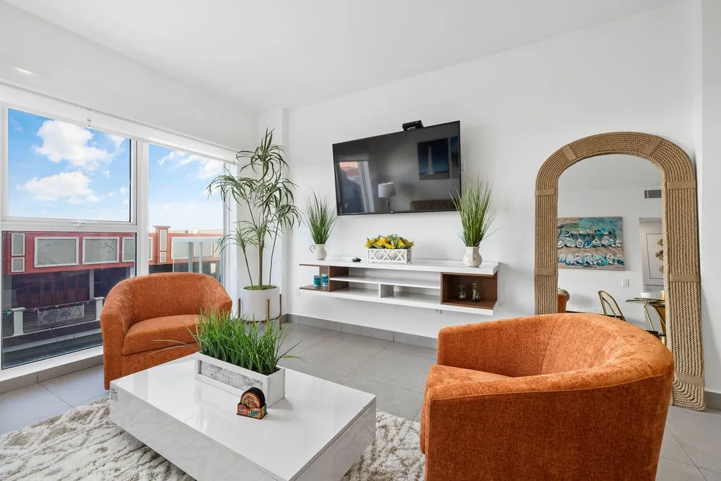 Settle into this bright living room where modern comfort meets relaxed coastal style. Sink into plush seating, stream your favorites, and soak in natural light from expansive windows.