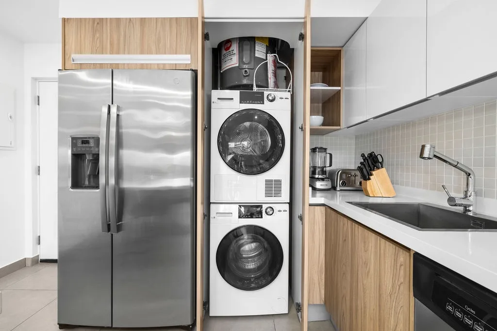 Your modern kitchen is equipped with stainless steel appliances and thoughtfully integrates a stacked washer and dryer, making it easy to stay organized during your stay.