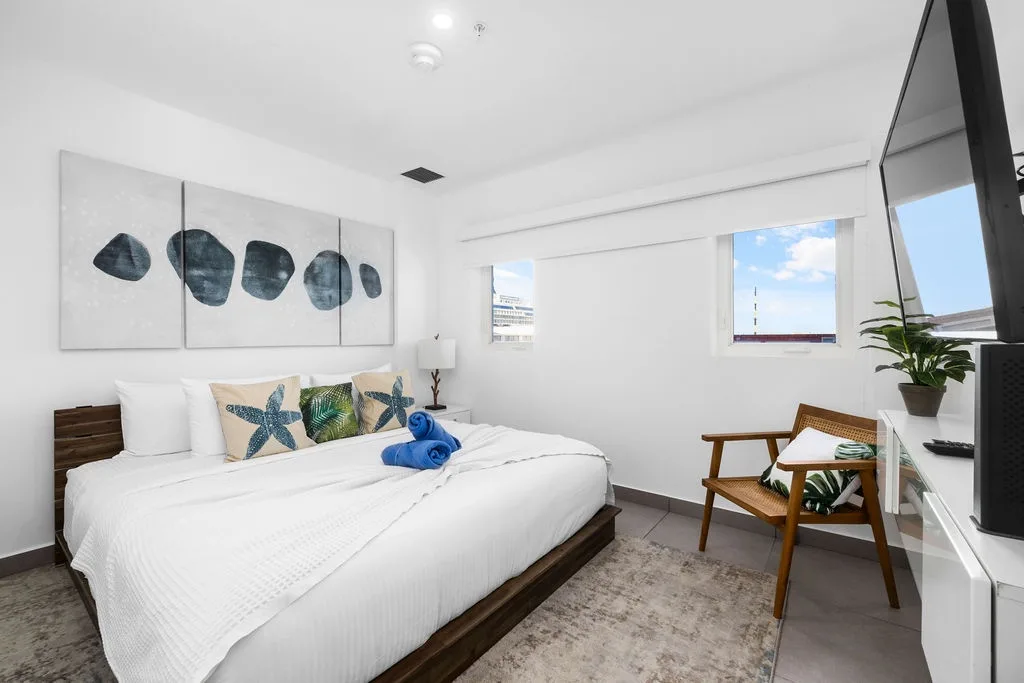 Sink into crisp white linens and let the coastal-inspired art set the mood for your restful escape. Natural light fills your space, creating a tranquil retreat.