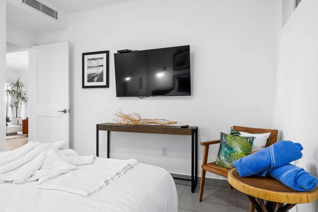 Unwind in your serene retreat where crisp white linens and modern amenities welcome you, with fresh towels ready and your favorite shows on the wall-mounted TV.