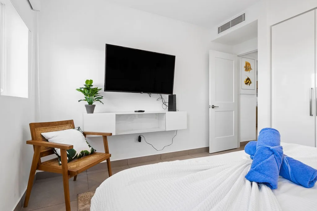 Unwind in your serene bedroom with a wall-mounted TV for your entertainment, climate control for comfort, and thoughtful touches like plush towels awaiting your arrival.