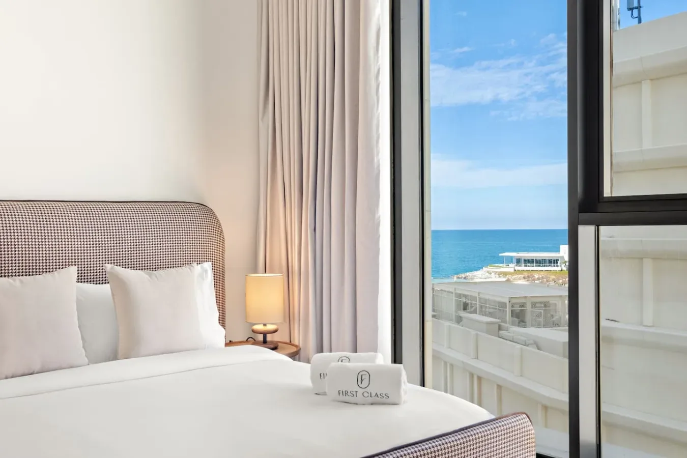 Un dormitorio con una cama junto a una ventana con vista al mar.