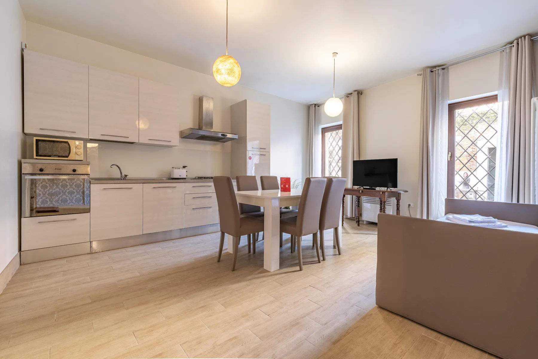 An open-plan kitchen and dining area with a television and seating.