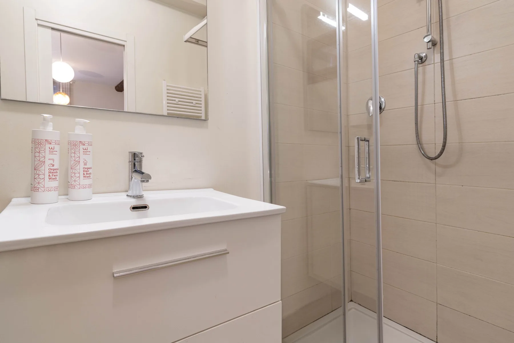 Un baño con un lavabo junto a una ducha de vidrio.