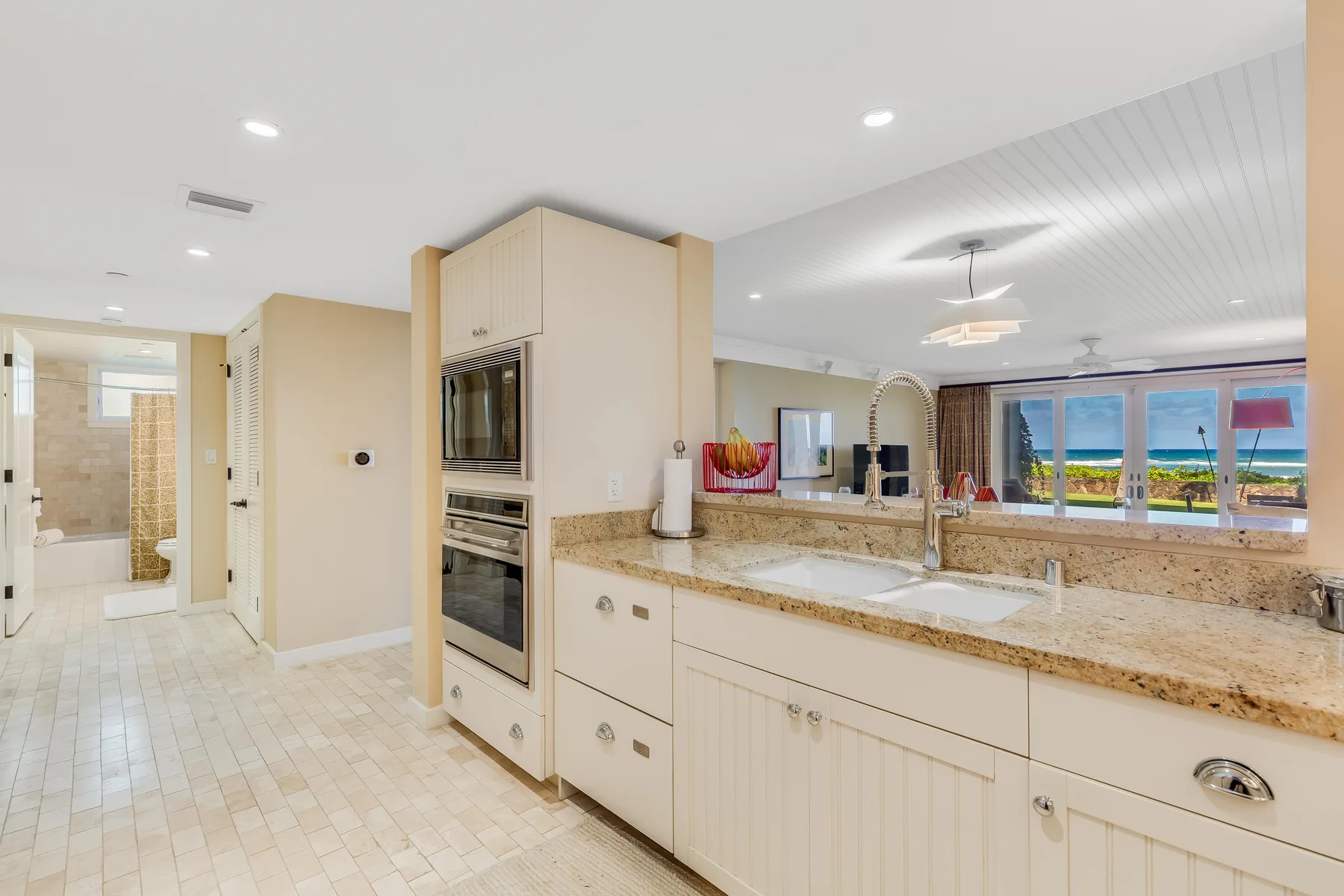 A bright kitchen with a long counter and a sink beneath the windows.
