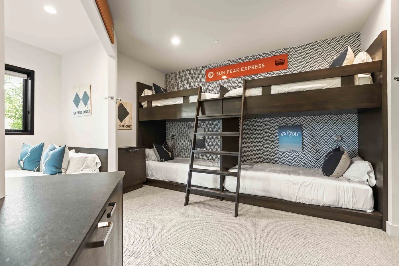 A bunk-bed sleeping area with a dark ladder and patterned wall.