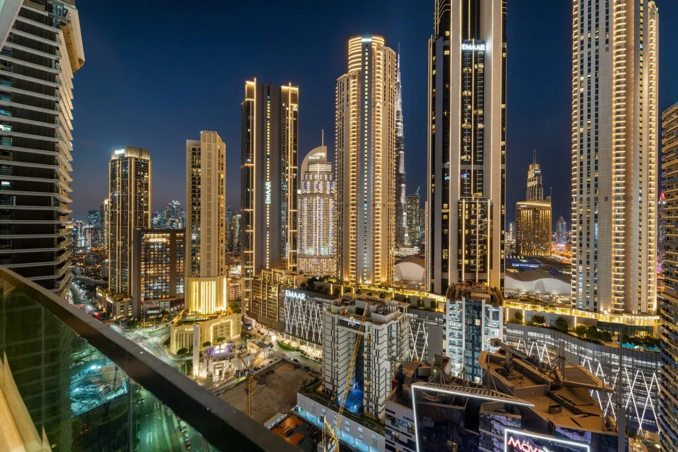 A nighttime city skyline with illuminated high-rise buildings and streets below.