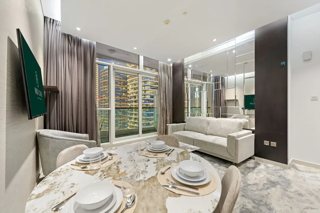 A bright living room with a dining table and seating beside mirrored walls.