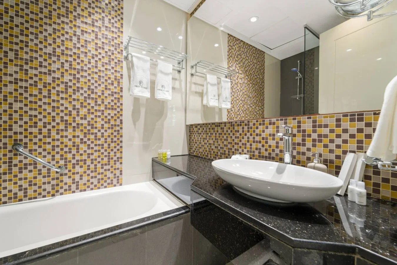 A bathroom with a bathtub and a sink beneath a large mirror.