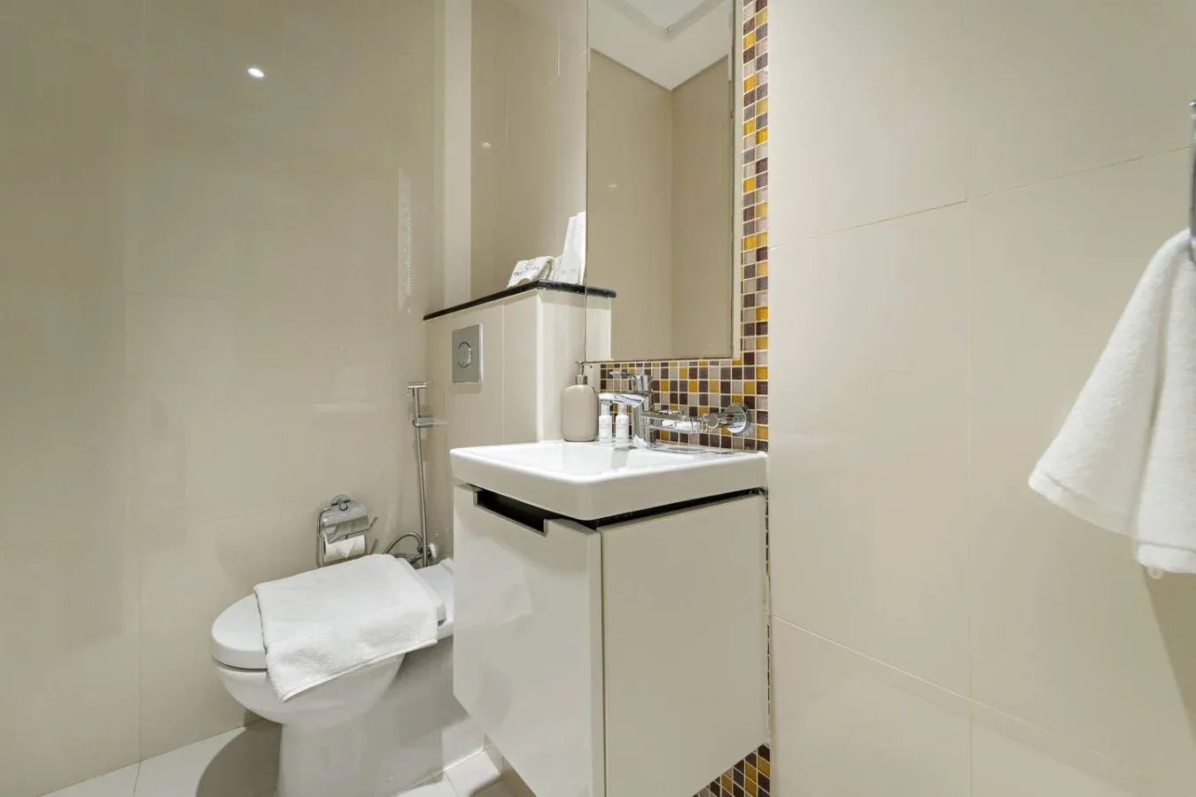 A bathroom with a sink, mirror, and toilet.