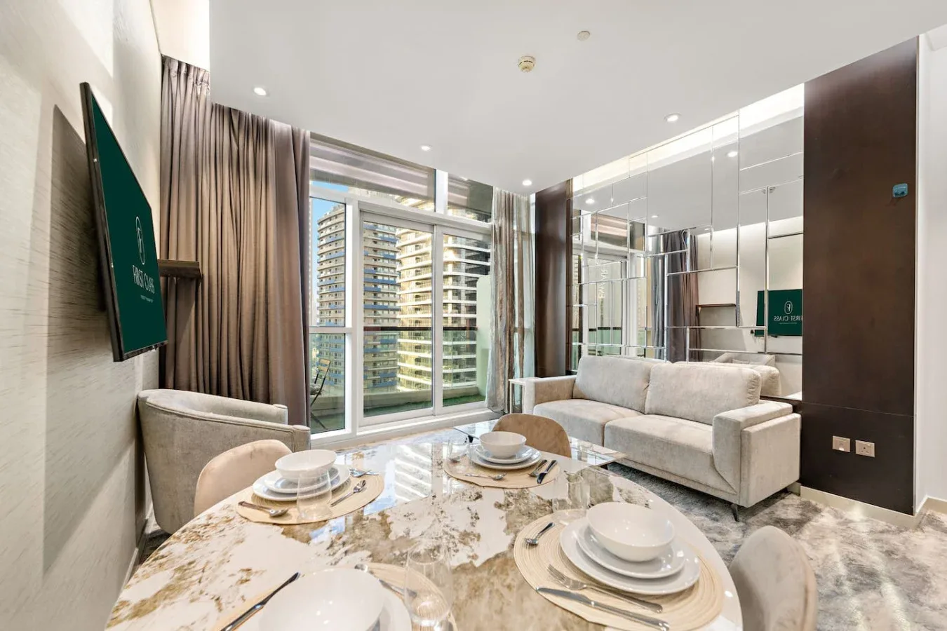 A bright living and dining area with a sofa, table, and large windows.