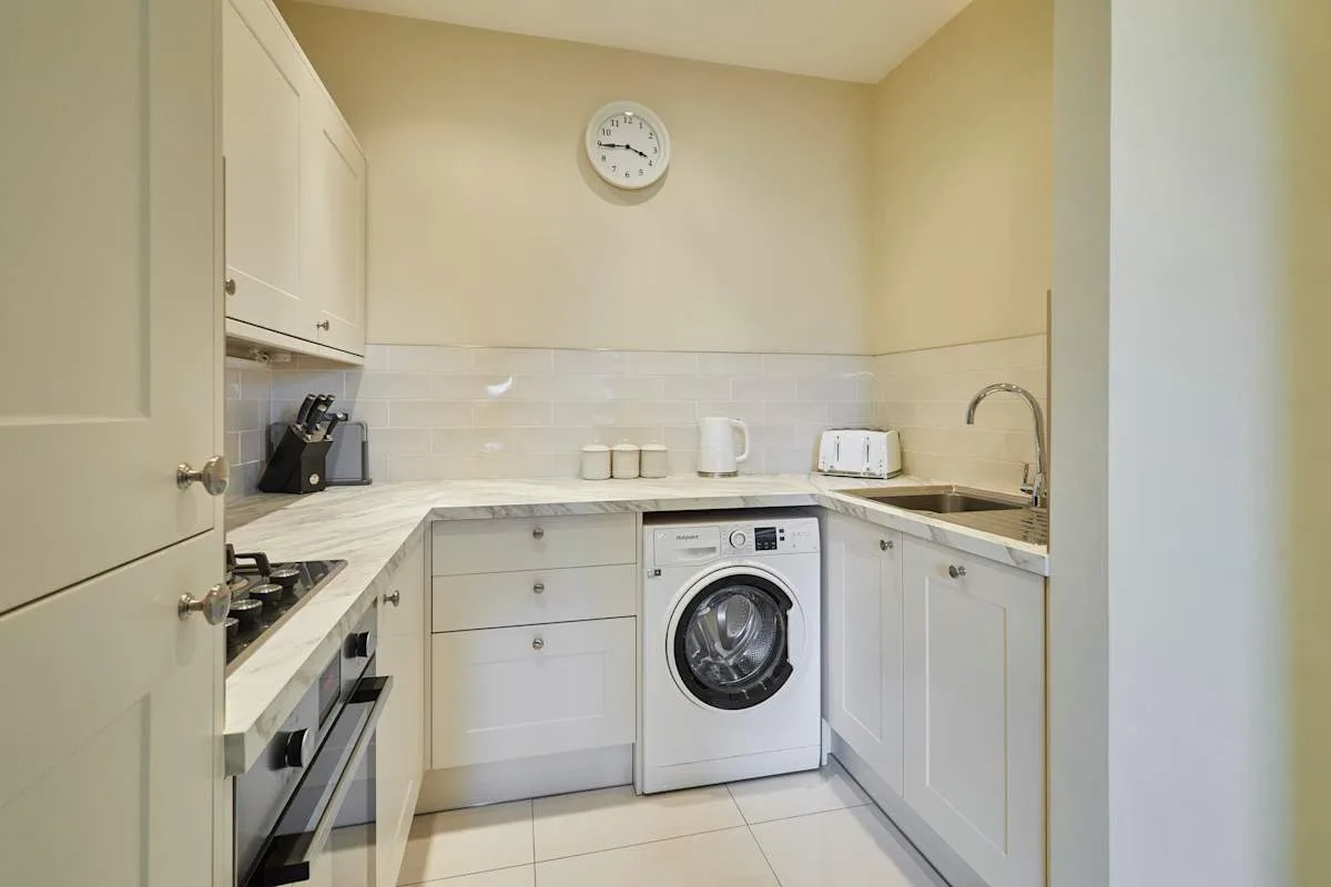 A compact kitchen with a washing machine beneath the counter.