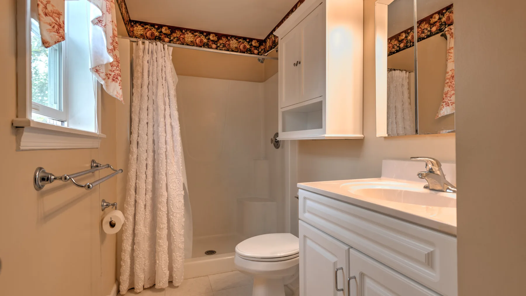 A bathroom with a shower, toilet, and sink vanity.