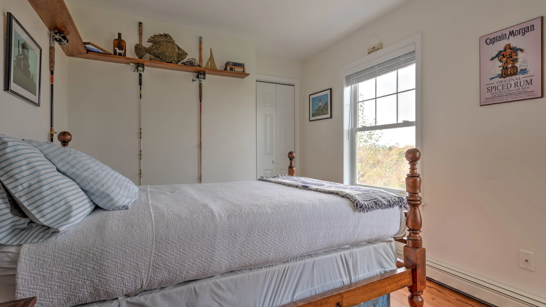A bedroom with a neatly made bed beside a window.