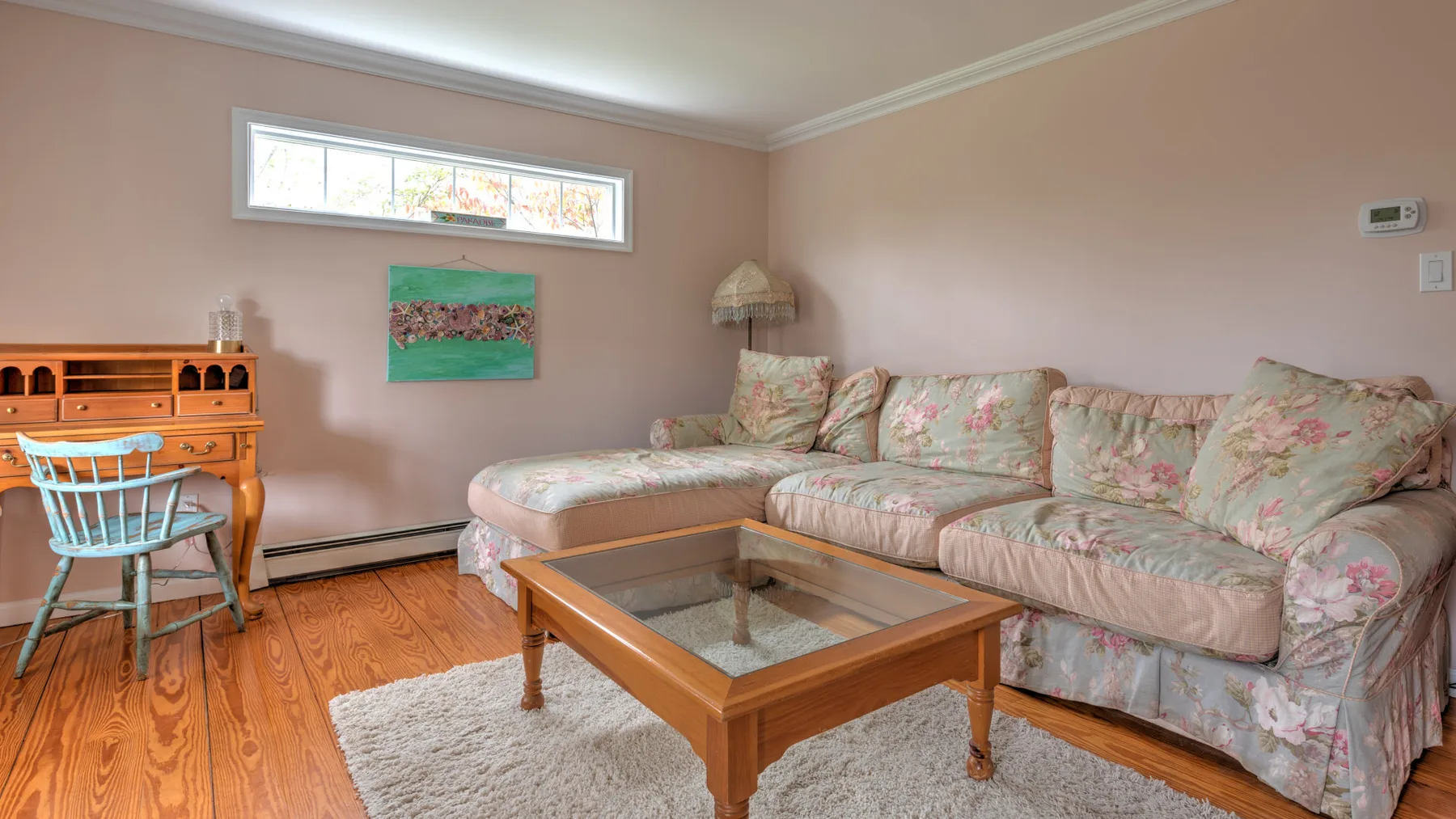 A living room with floral seating and a wooden coffee table.