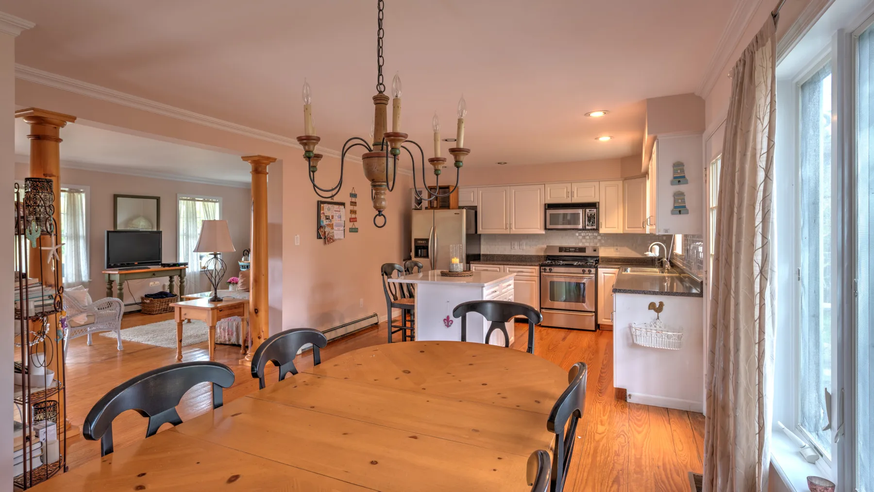 Comedor y cocina de planta abierta con una mesa de madera e isla de cocina.