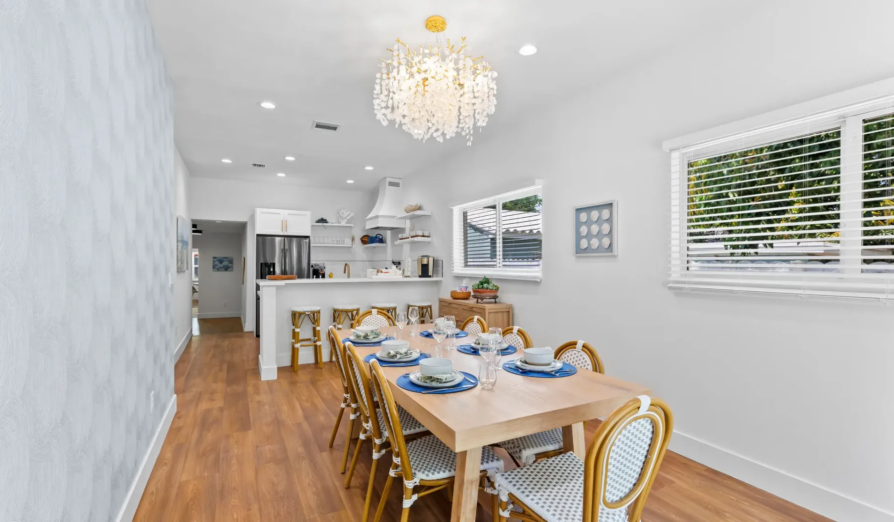 Un comedor luminoso con una mesa larga junto a la cocina.