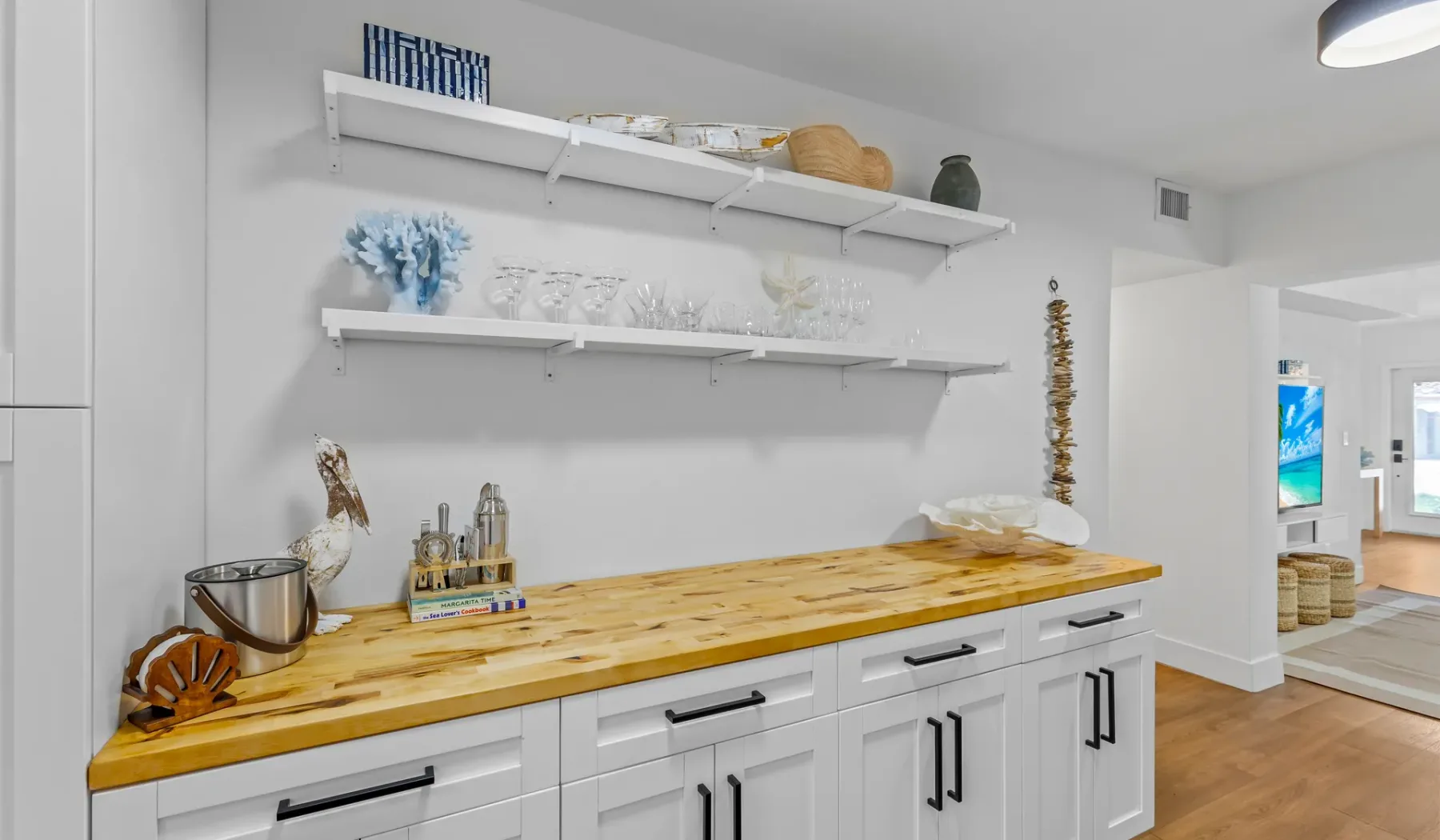 Una cocina luminosa con una larga encimera de madera y estantes abiertos.