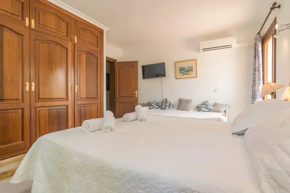 Un dormitorio con una cama grande, armarios de madera y una ventana.