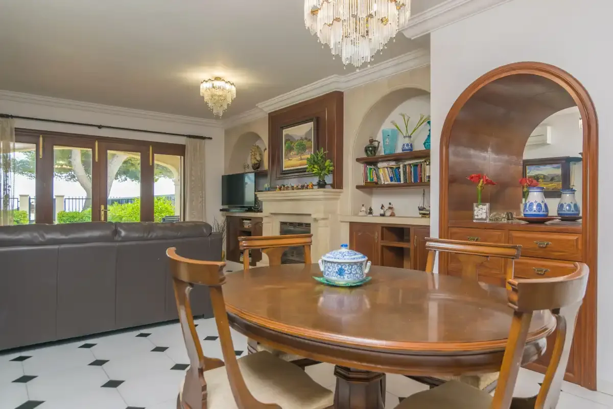 Sala de estar y comedor con una mesa grande, asientos y ventanas.