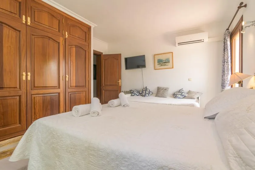 Un dormitorio con una cama grande, armarios de madera y una ventana.