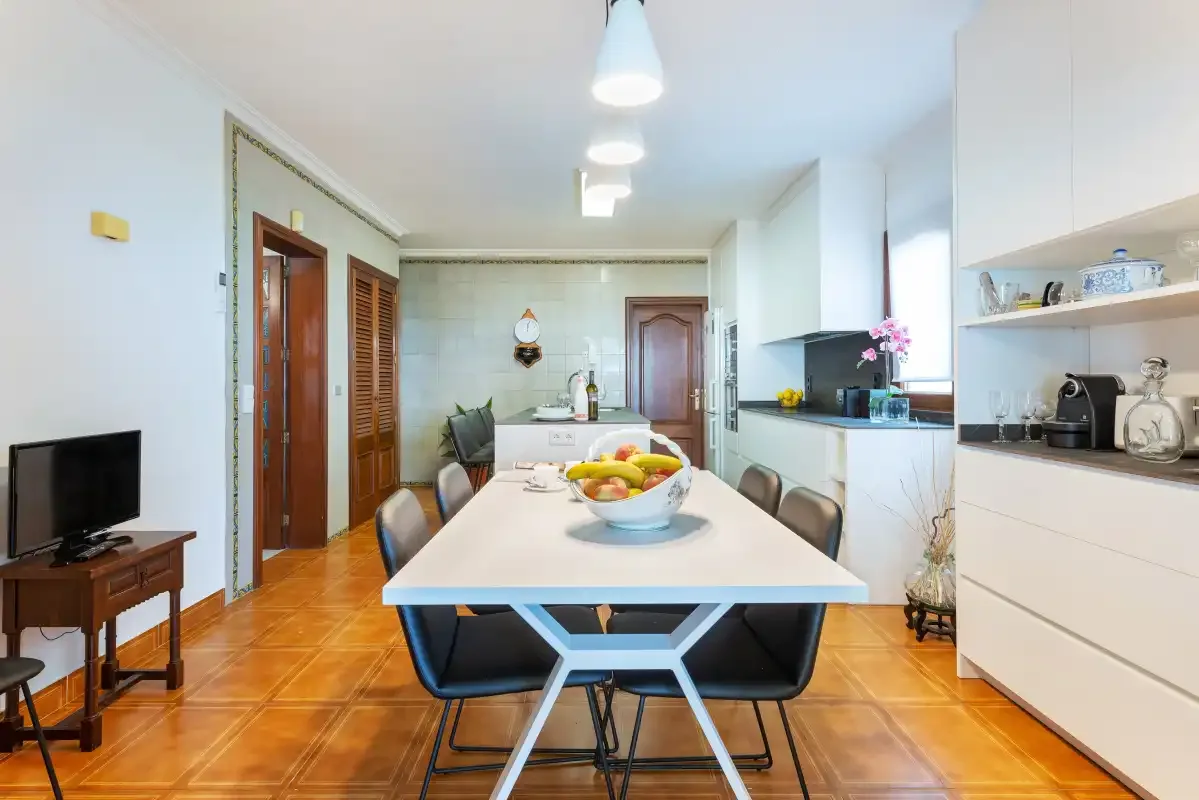 Un comedor luminoso con una mesa larga junto a la cocina.