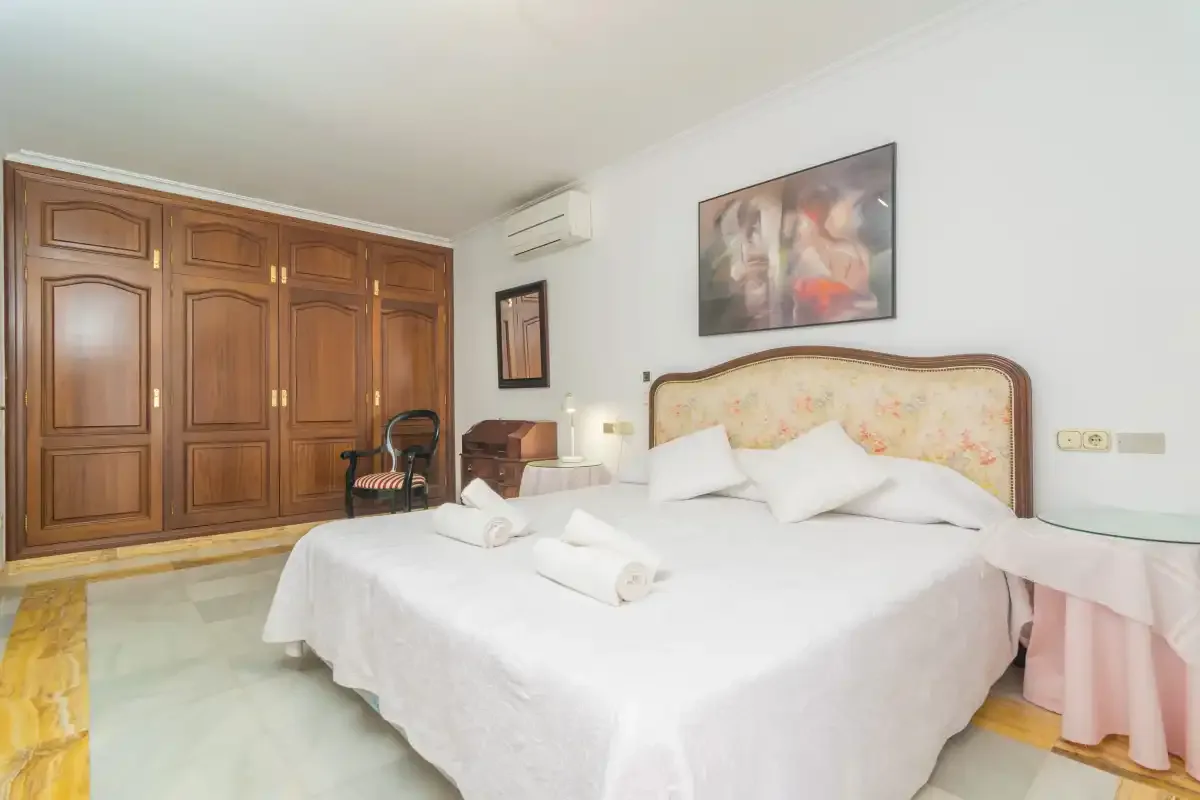 Un dormitorio con una cama grande y armarios de madera.