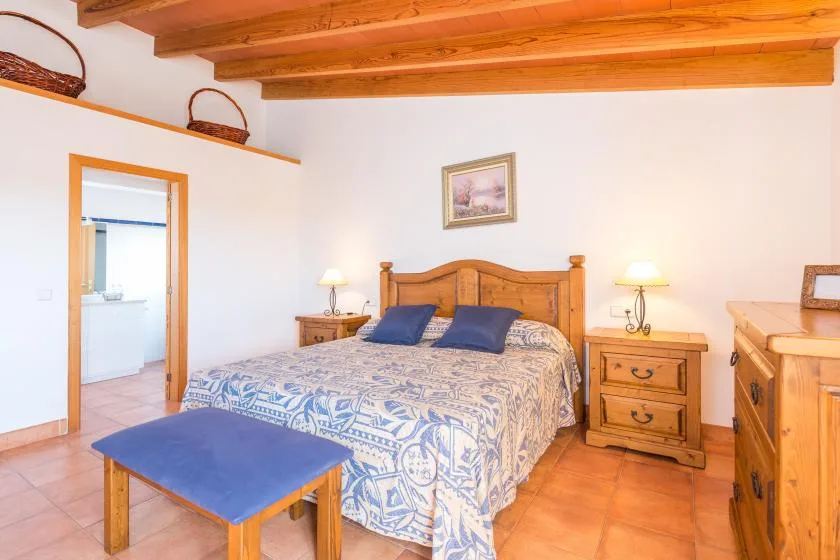 A bedroom with a wooden bed, patterned bedding, and matching bedside tables.