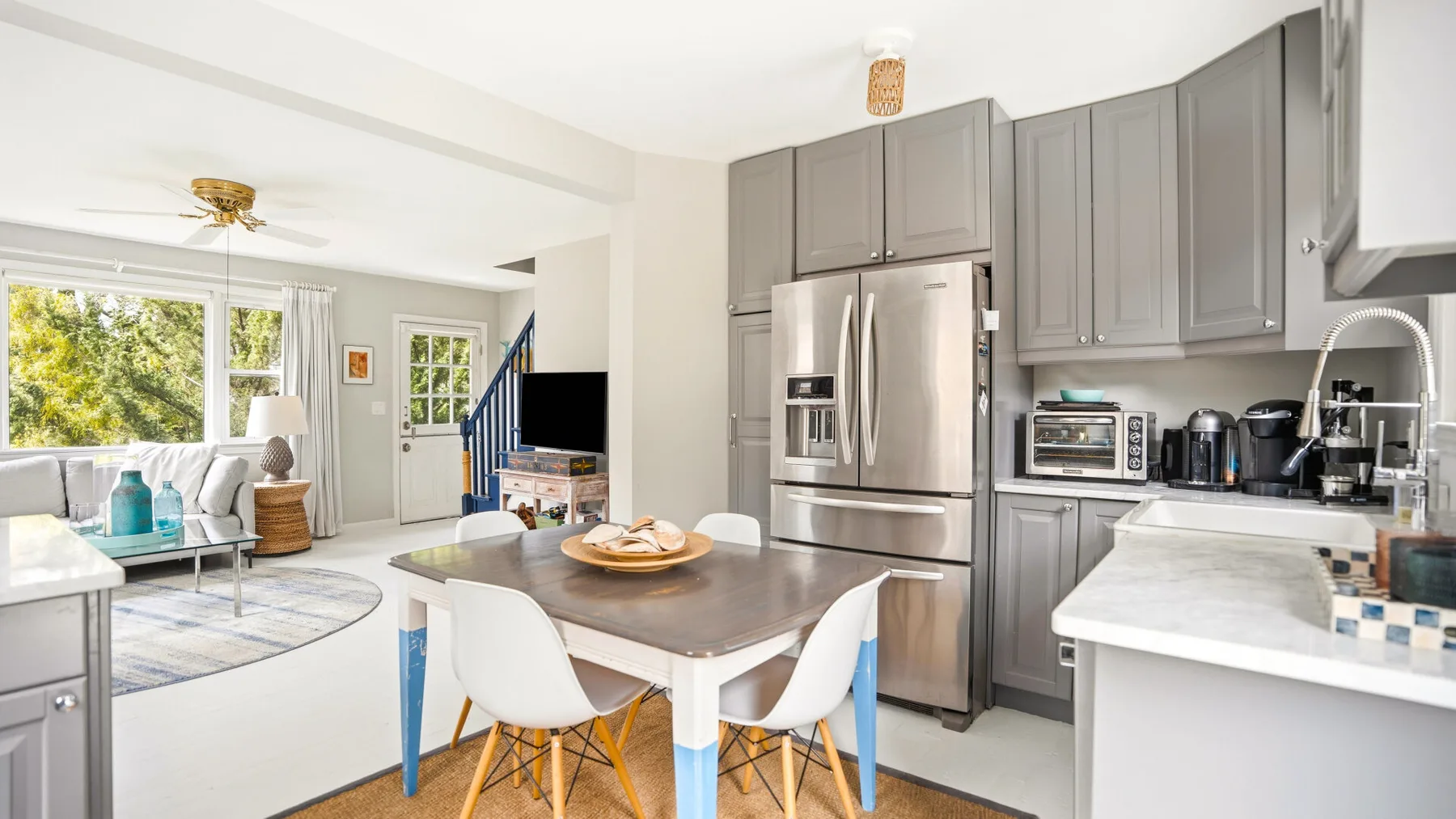 Cocina y sala de estar de concepto abierto, con una mesa de comedor y ventanas amplias.