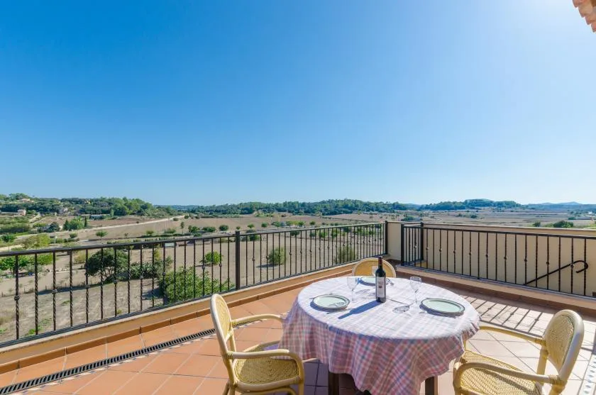 A terrace with a round table and open views across the landscape.