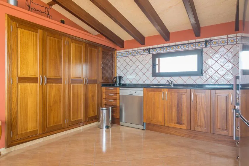 A kitchen with wooden cabinets, a countertop, and a window.