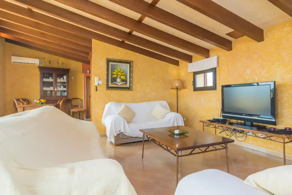 A living room with seating, a coffee table, and a television.