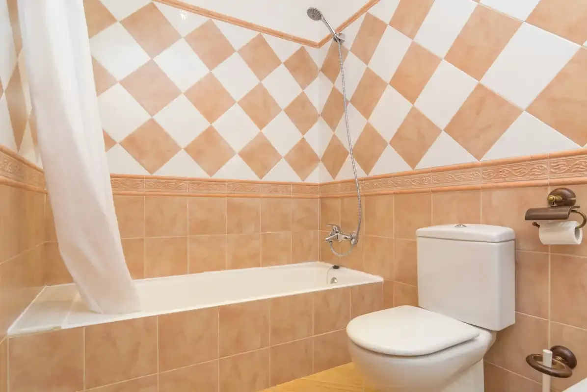 A tiled bathroom with a bathtub, shower, and toilet.