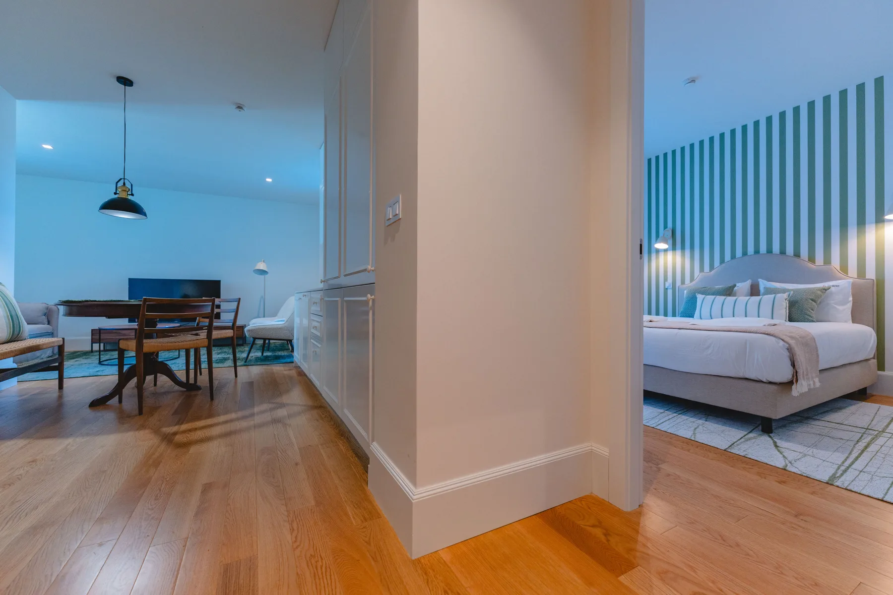 Se ven un dormitorio y una zona de comedor a ambos lados de una pared central.