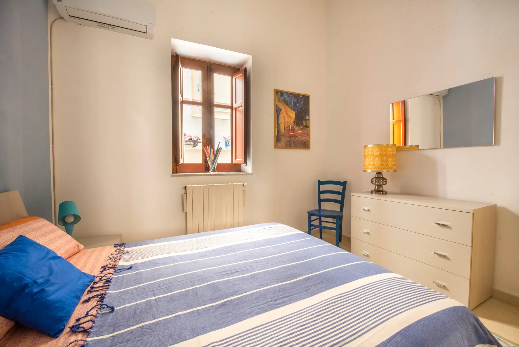 Un dormitorio con una cama, una ventana y una cómoda.