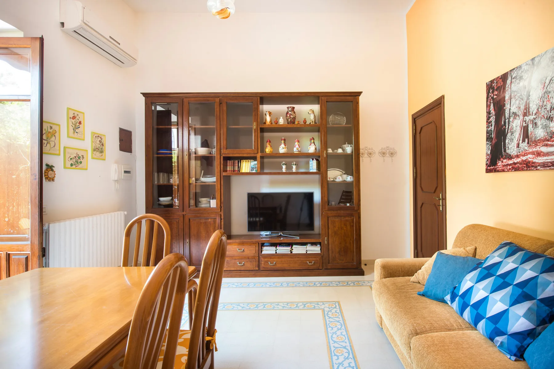 Una sala de estar con mueble para televisión, mesa de comedor y asientos.