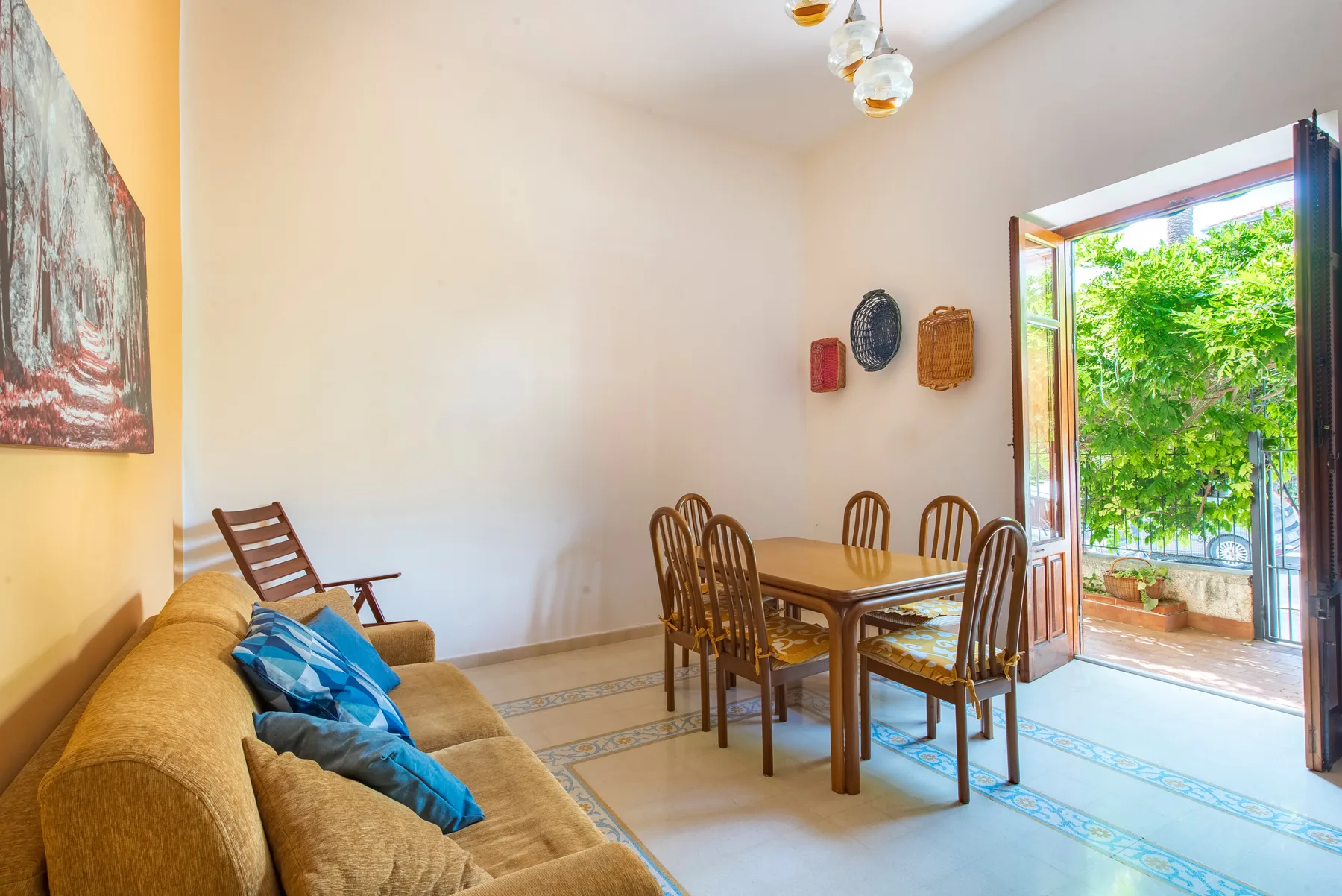 Comedor con una mesa de madera y sillas junto a una puerta abierta al balcón.