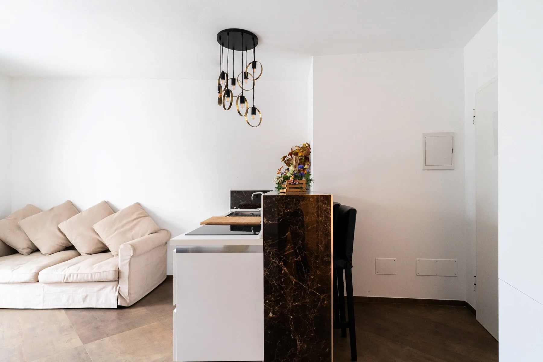 A bright living room with light-colored seating and a small dining table.