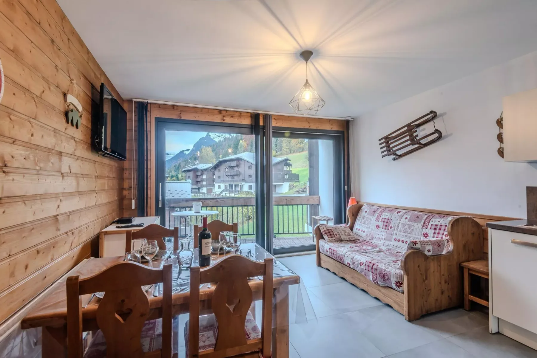 A dining and sitting area opens onto a balcony with mountain views.