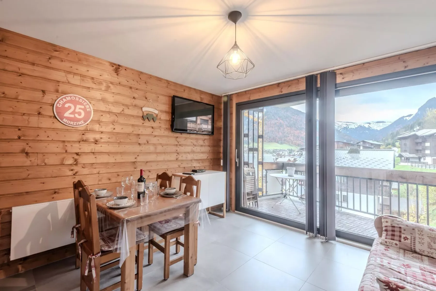 A wood-paneled dining area opens onto a balcony with mountain views.