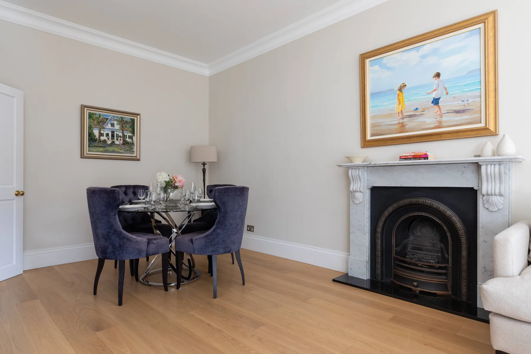 A dining area with upholstered seating and a fireplace along the wall.