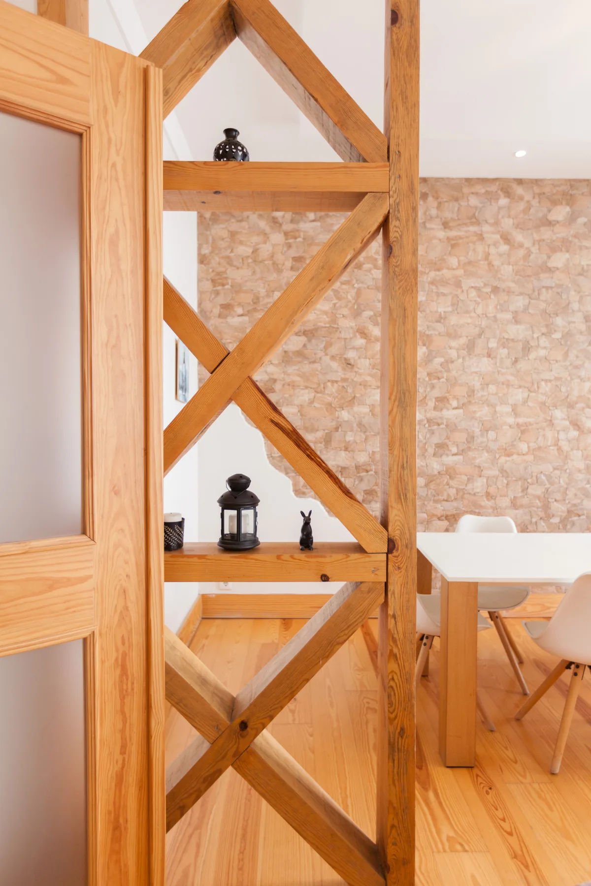 Comedor con mesa de madera y una celosía decorativa de madera.