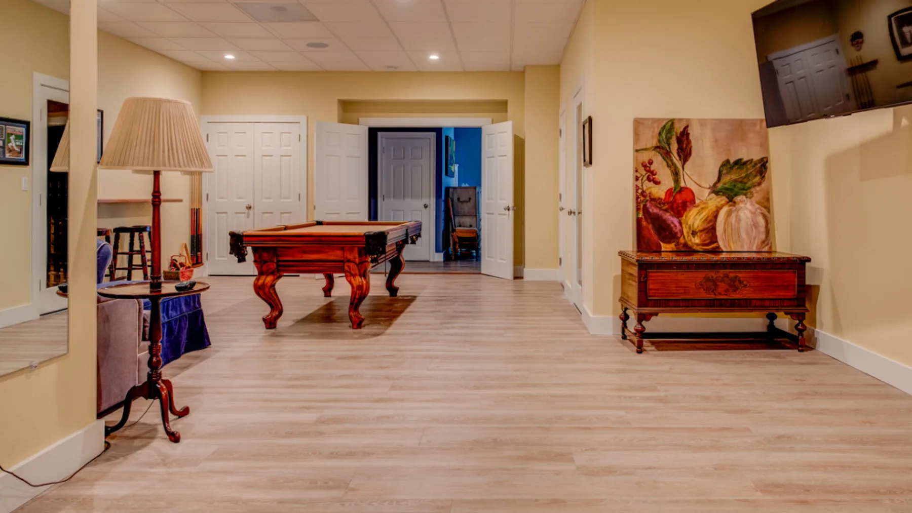 A spacious game room features a pool table and a decorative wooden chest.