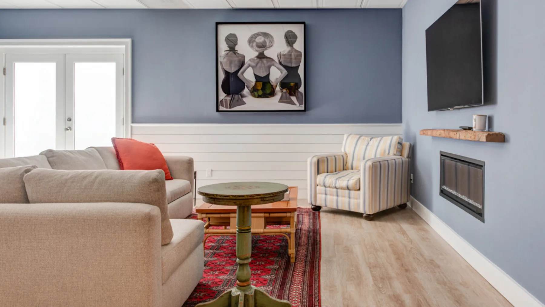 A living room with seating, a coffee table, and a wall-mounted television.