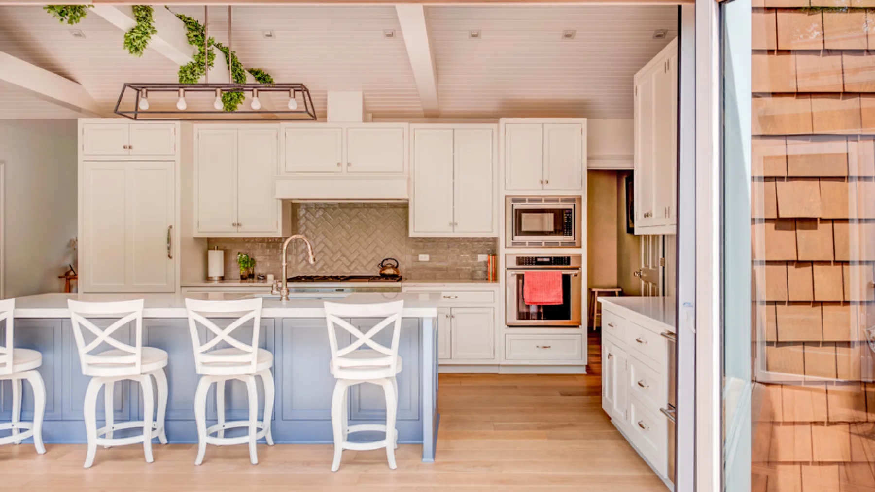 A bright kitchen with a central island and several stools.