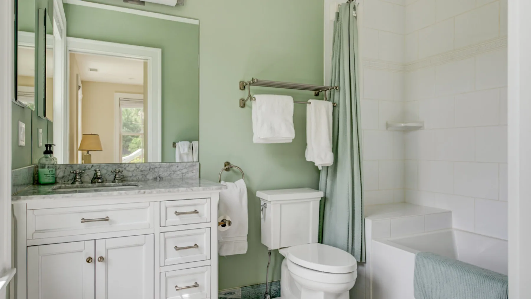A bathroom with a vanity, toilet, and bathtub.