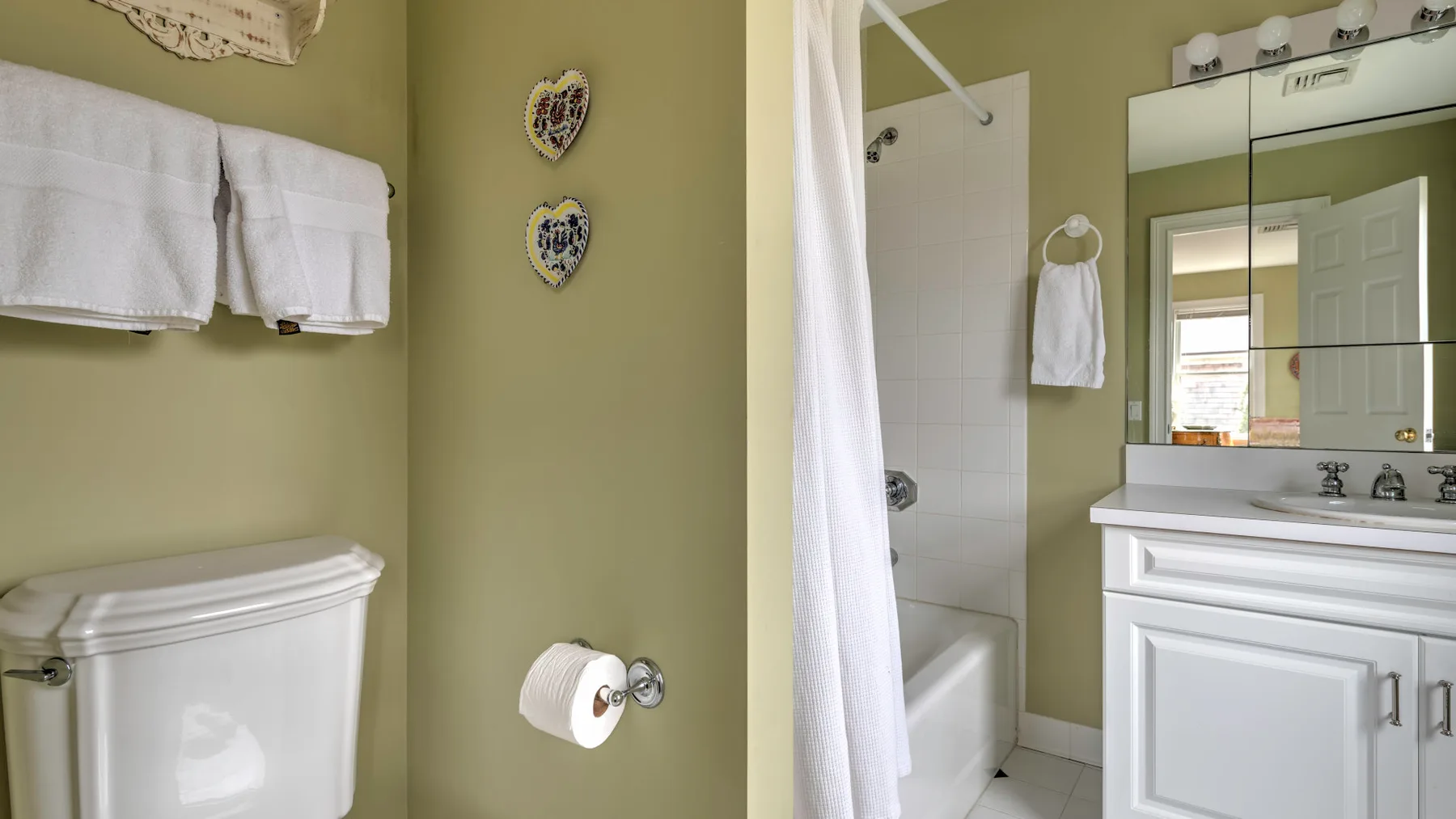 Un baño con bañera, cortina de ducha, inodoro y lavabo.
